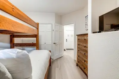 a bedroom with a bed and a dresser with a tv at Walk to Ski Lift and Hot Tubs! Mtn-View Keystone Gem in Keystone