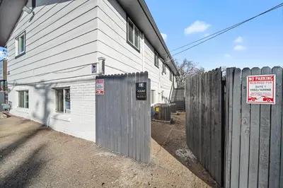 a fence next to a house with a sign on it at Near Downtow 3Bed 2 Bath in Denver Explore Colorado in Denver