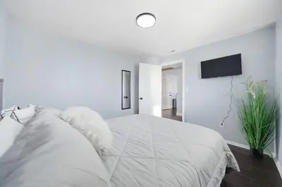 a white bedroom with a large bed and a flat screen tv at Near Downtow 3Bed 2 Bath in Denver Explore Colorado in Denver