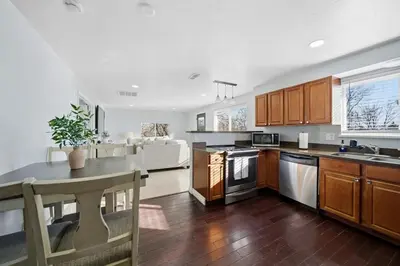 a kitchen with wooden cabinets and a kitchen island with a table at Near Downtow 3Bed 2 Bath in Denver Explore Colorado in Denver