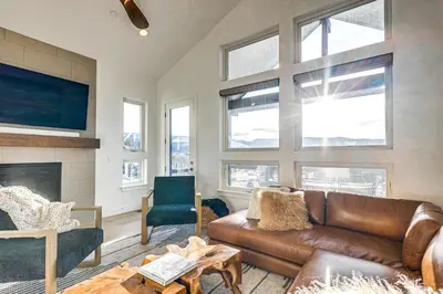 a living room with a leather couch and a fireplace at Hot Tub and Amazing Views Luxury Winter Park Haven! in Winter Park