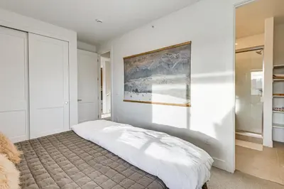 a bedroom with a bed with a painting on the wall at Hot Tub and Amazing Views Luxury Winter Park Haven! in Winter Park