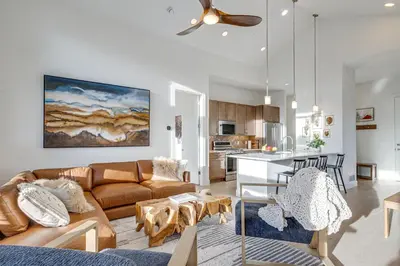 a living room with a couch and a table and a kitchen at Hot Tub and Amazing Views Luxury Winter Park Haven! in Winter Park