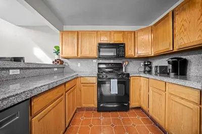 a kitchen with wooden cabinets and a black stove at Golden View Townhouse - Walk to Downtown! in Golden