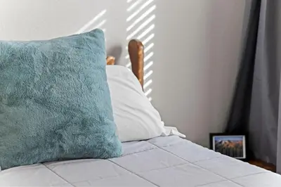 a bed with a blue pillow and a picture at Golden View Townhouse - Walk to Downtown! in Golden