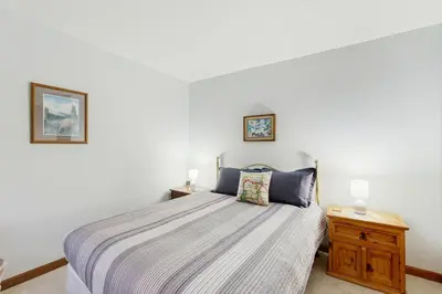 a bedroom with a bed and a wooden night stand at Next To Nature in Grand Lake