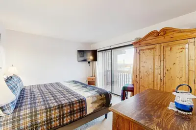 a bedroom with a bed and a table and a window at Next To Nature in Grand Lake