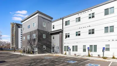 a large white building next to a parking lot at Landing Chic 1BD in Harvey Park South in Englewood