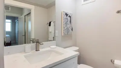 a white bathroom with a sink and a mirror at Landing Chic 1BD in Harvey Park South in Englewood
