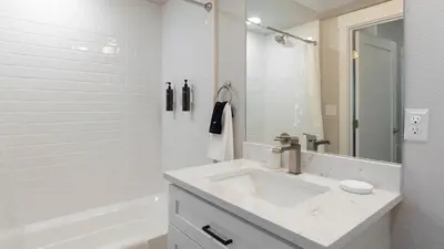 a white bathroom with a sink and a tub at Landing Chic 1BD in Harvey Park South in Englewood
