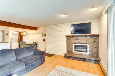 a living room with a couch and a stone fireplace at Ski, Hike and Snowmobile Mtn-View Grand Lake Gem! in Grand Lake