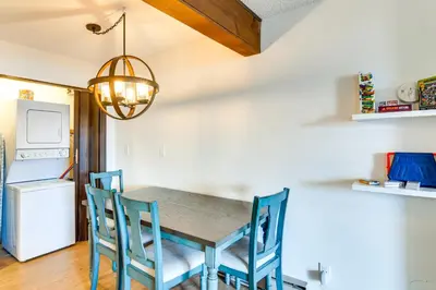 a dining room table with blue chairs and a light fixture at Ski, Hike and Snowmobile Mtn-View Grand Lake Gem! in Grand Lake