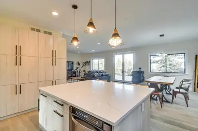 a kitchen with white cabinets and a table in a room at Great for Gatherings! Evergreen Getaway with Hot Tub in Evergreen