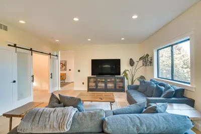 a living room with blue couches and a tv at Great for Gatherings! Evergreen Getaway with Hot Tub in Evergreen