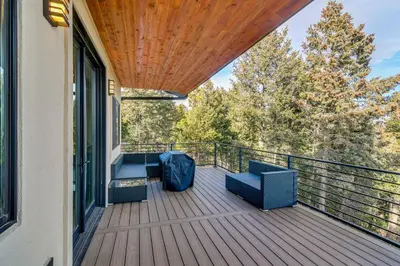 a balcony with a couch and chairs on a porch at Great for Gatherings! Evergreen Getaway with Hot Tub in Evergreen