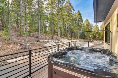 a jacuzzi tub on the deck of a house at Great for Gatherings! Evergreen Getaway with Hot Tub in Evergreen