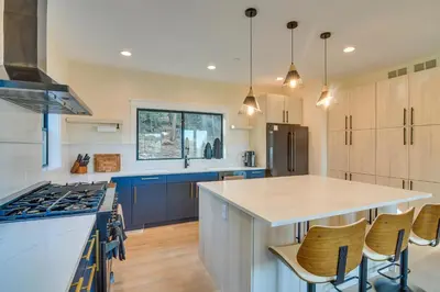 a kitchen with blue cabinets and a white counter top at Great for Gatherings! Evergreen Getaway with Hot Tub in Evergreen