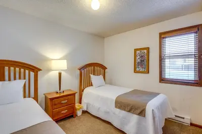 a bedroom with two beds and a lamp and a window at Steps to Free Ski Shuttle! Dtwn Winter Park Condo in Winter Park