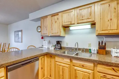 a kitchen with wooden cabinets and a sink at Steps to Free Ski Shuttle! Dtwn Winter Park Condo in Winter Park