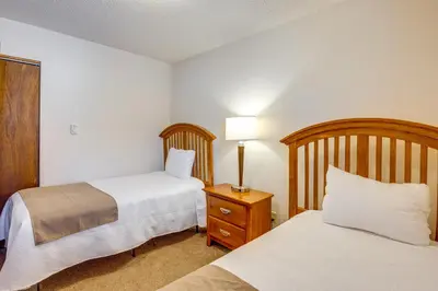 a hotel room with two beds and a lamp on a night stand at Steps to Free Ski Shuttle! Dtwn Winter Park Condo in Winter Park