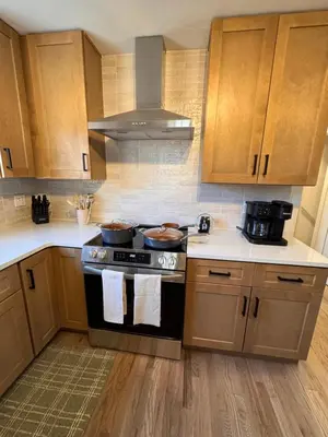 a kitchen with wooden cabinets and a stove top oven at Haus Vango in Arvada