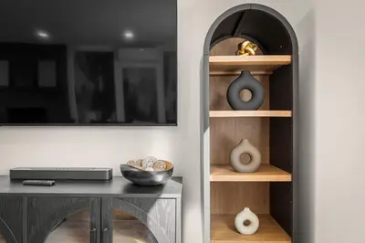 a room with a table and a shelf with vases at Haus Vango in Arvada