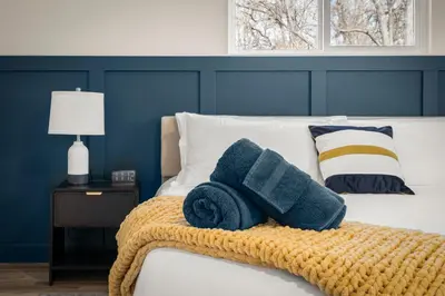 a bedroom with a bed with blue walls and towels at Haus Vango in Arvada