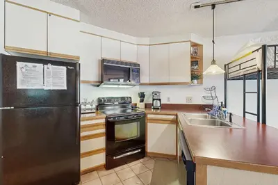 a kitchen with a black refrigerator and a sink at Iron Horse Resort #C1083 in Winter Park