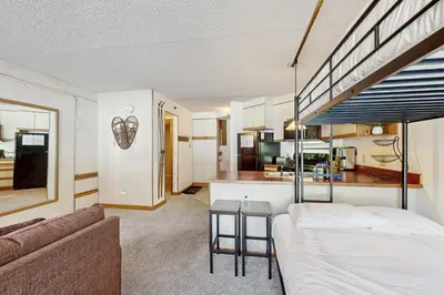 a living room with a bed and a kitchen at Iron Horse Resort #C1083 in Winter Park