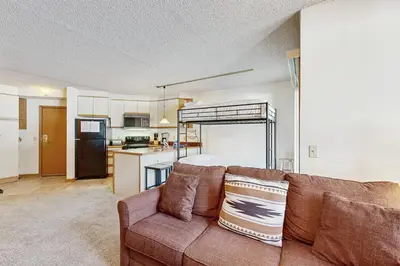 a living room with a couch and a kitchen at Iron Horse Resort #C1083 in Winter Park