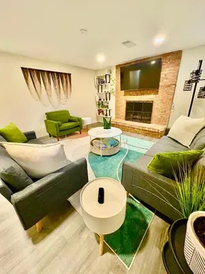 a living room with green furniture and a fireplace at Private Residence Below Basement in Thornton
