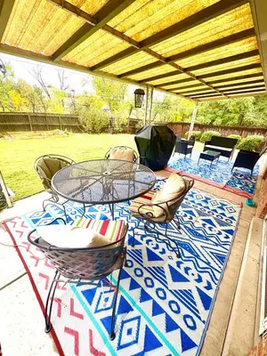 a patio with a table and chairs on a rug at Private Residence Below Basement in Thornton