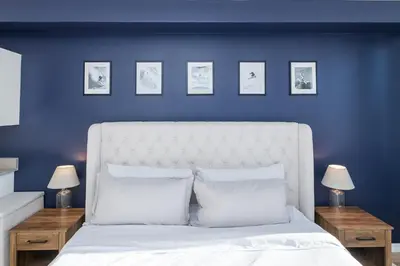 a bedroom with a white bed with blue walls at The Fox Den: Cozy & Fun with Amazing Views in Fraser