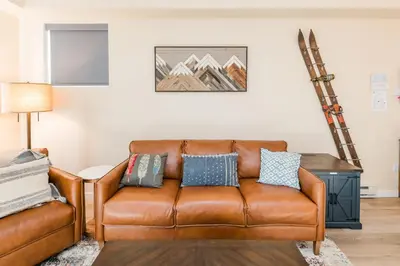 a living room with a brown leather couch at The Fox Den: Cozy & Fun with Amazing Views in Fraser
