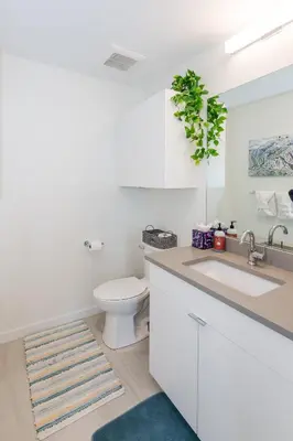 a white bathroom with a toilet and a sink at The Fox Den: Cozy & Fun with Amazing Views in Fraser