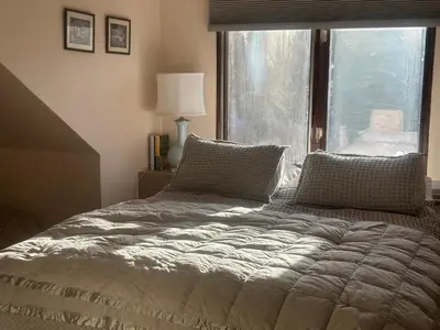 a bed in a bedroom with a large window at Modern barn by the creek in Evergreen