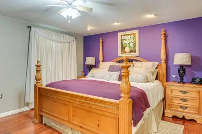 a bedroom with a large bed with purple walls at Group Getaway 3 Mi to Cherry Creek State Park! in Aurora