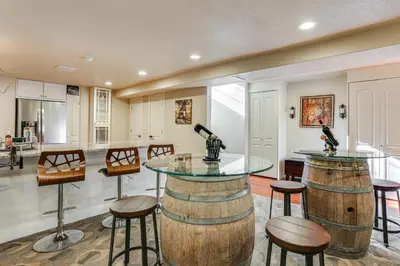 a kitchen with a bar with two wine barrels at Group Getaway 3 Mi to Cherry Creek State Park! in Aurora