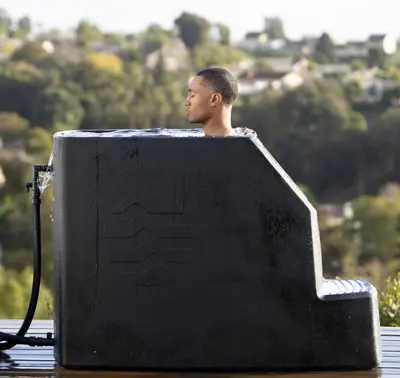 a man sitting in a bath tub in the water at Spa Getaway with Open Space Access Sauna & Hot Tub & Cold Plunge in Boulder
