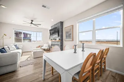 a living room with a white table and chairs and a couch at 10 min to DIA, Walk to the Gaylord! in Aurora