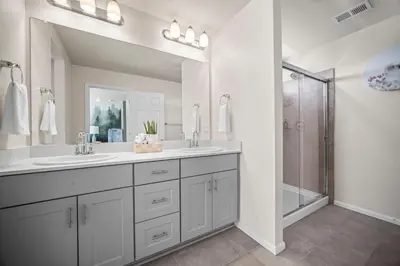 a white bathroom with two sinks and a shower at 10 min to DIA, Walk to the Gaylord! in Aurora