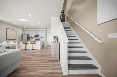 a staircase leading to a living room and a kitchen at 10 min to DIA, Walk to the Gaylord! in Aurora