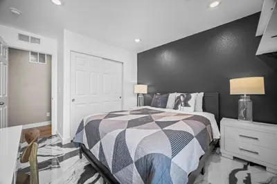 a bedroom with a bed and a black wall at 10 min to DIA, Walk to the Gaylord! in Aurora