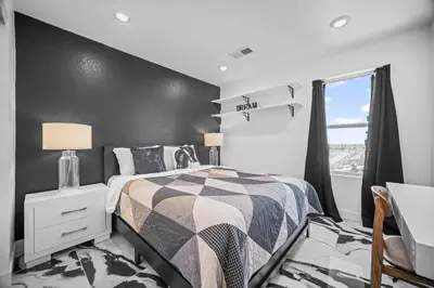 a bedroom with a bed and a black wall at 10 min to DIA, Walk to the Gaylord! in Aurora