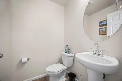 a bathroom with a sink and a toilet and a mirror at 10 min to DIA, Walk to the Gaylord! in Aurora