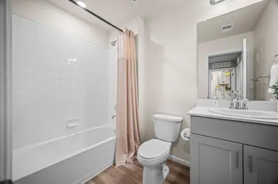 a white bathroom with a toilet and a sink at 10 min to DIA, Walk to the Gaylord! in Aurora
