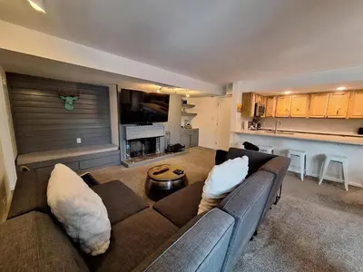 a living room with a couch and a kitchen at Keystone Charm- Wild Irishman 3BR Mountain Escape condo in Keystone