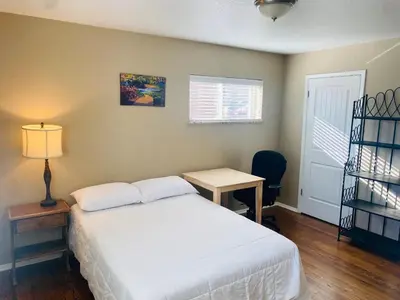 a bedroom with a bed and a table and a window at Master Bedroom and Bath in Arvada