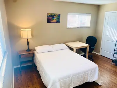 a bedroom with a bed and a table and a lamp at Master Bedroom and Bath in Arvada