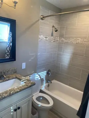 a bathroom with a toilet and a tub and a sink at Master Bedroom and Bath in Arvada